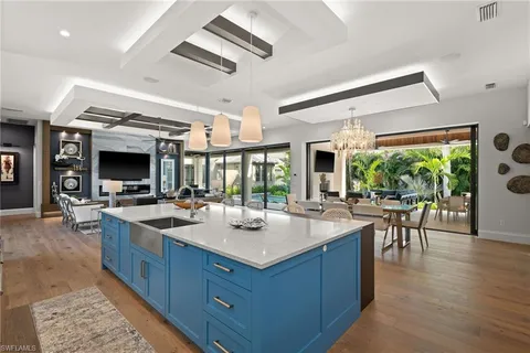 a dining hall with stainless steel appliances granite countertop a stove oven and a view of living room