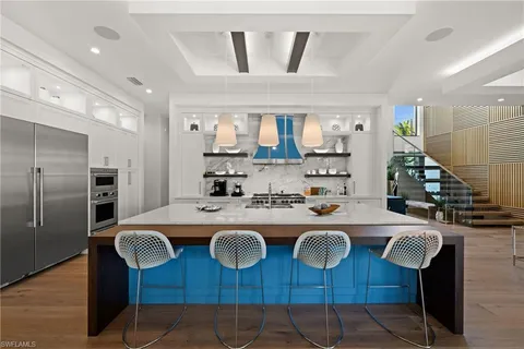 a kitchen with a sink a stove and chairs