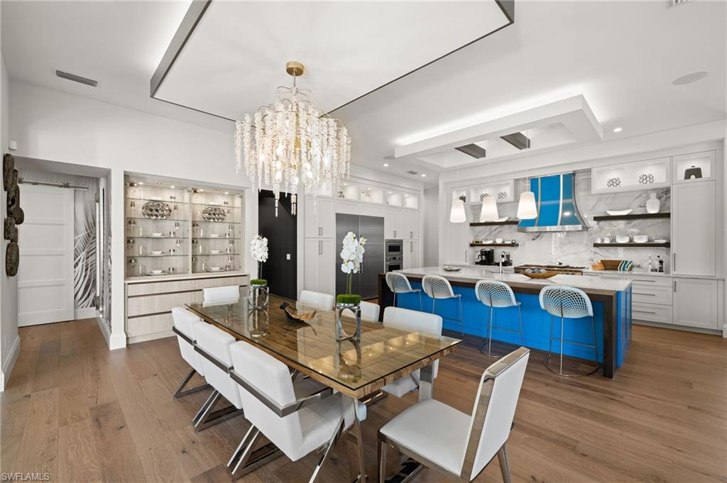 255 21st Avenue South Naples, FL 34102 - Photo 15 of 36 a view of a dining room with furniture wooden floor and chandelier