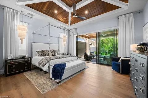 a spacious bedroom with a bed and a dresser next to a window