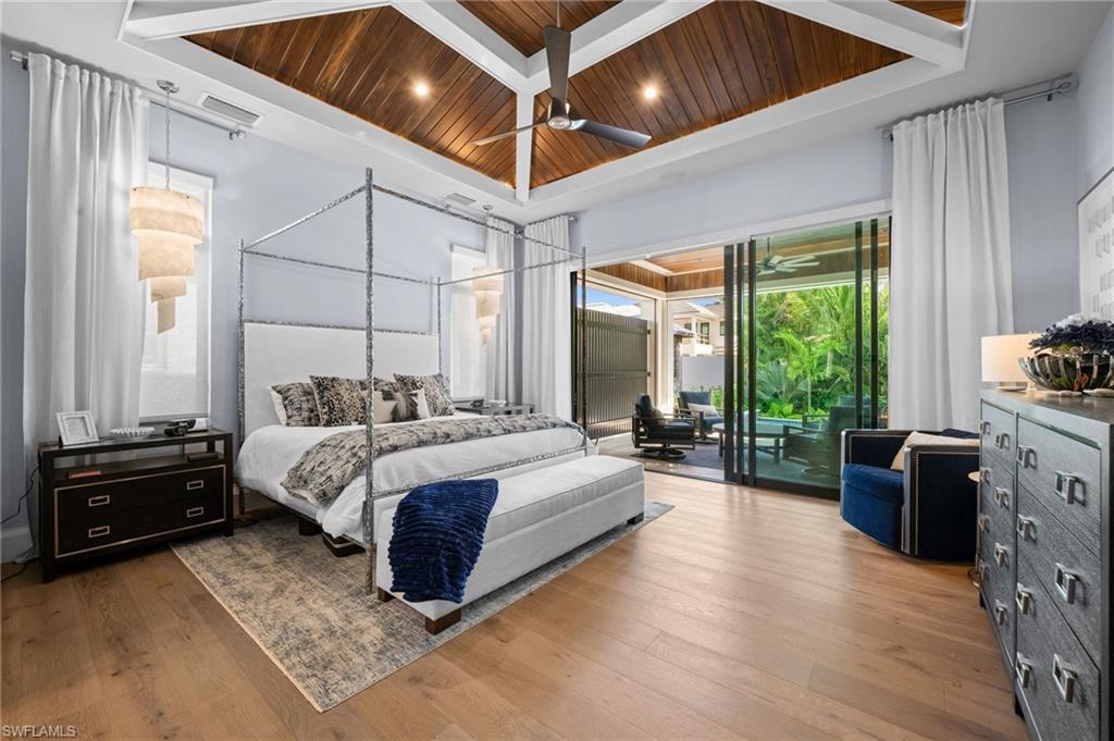 255 21st Avenue South Naples, FL 34102 - Photo 18 of 36 a spacious bedroom with a bed and a dresser next to a window