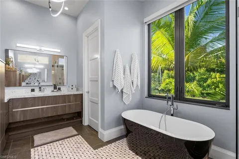 a bathroom with a tub sink and mirror