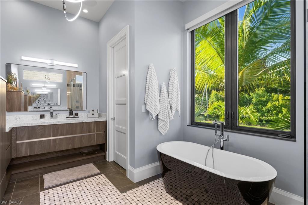 255 21st Avenue South Naples, FL 34102 - Photo 21 of 36 a bathroom with a tub sink and mirror
