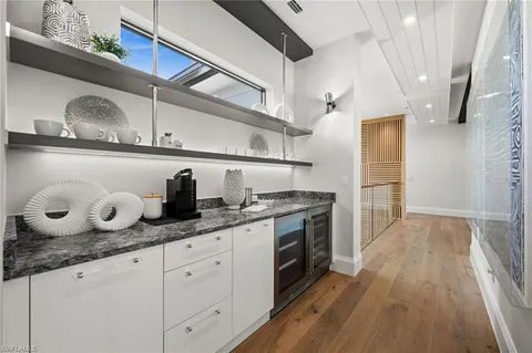 a kitchen with granite countertop a sink a stove and cabinets