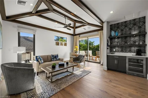 a living room with furniture a large window and wooden floor