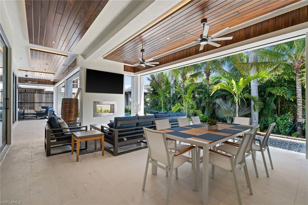 255 21st Avenue South Naples, FL 34102 - Photo 5 of 36 a view of a patio with table and chairs and potted plants