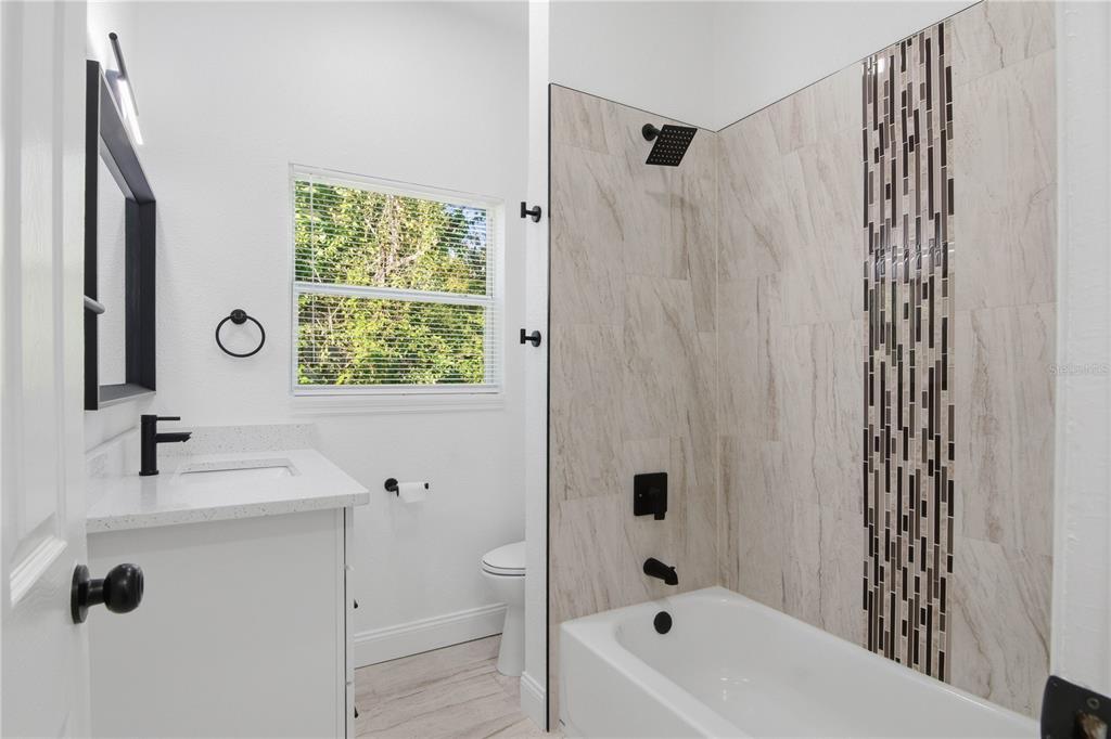 5601 Meridian Way Orlando, FL 32808 - Photo 19 of 34 a bathroom with a bathtub a sink and a mirror