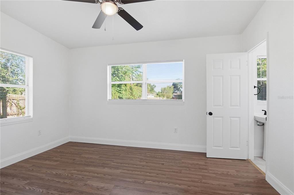 5601 Meridian Way Orlando, FL 32808 - Photo 21 of 34 an empty room with wooden floor and windows
