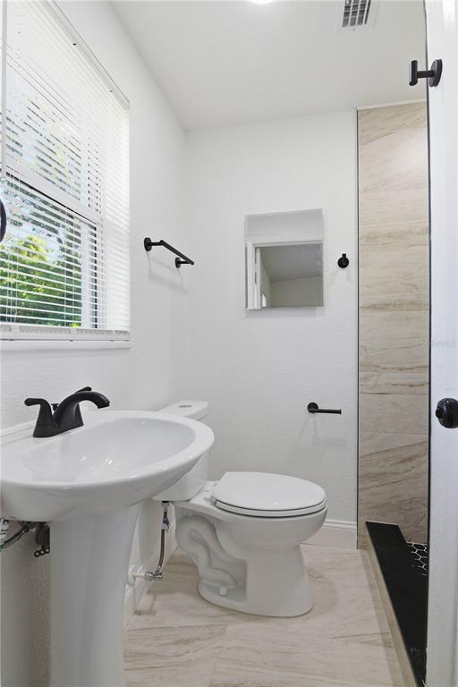 5601 Meridian Way Orlando, FL 32808 - Photo 24 of 34 a bathroom with a sink toilet and mirror