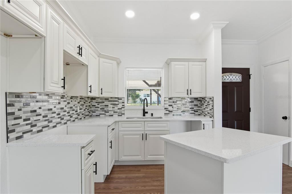 5601 Meridian Way Orlando, FL 32808 - Photo 6 of 34 a kitchen with granite countertop a sink stove and cabinets