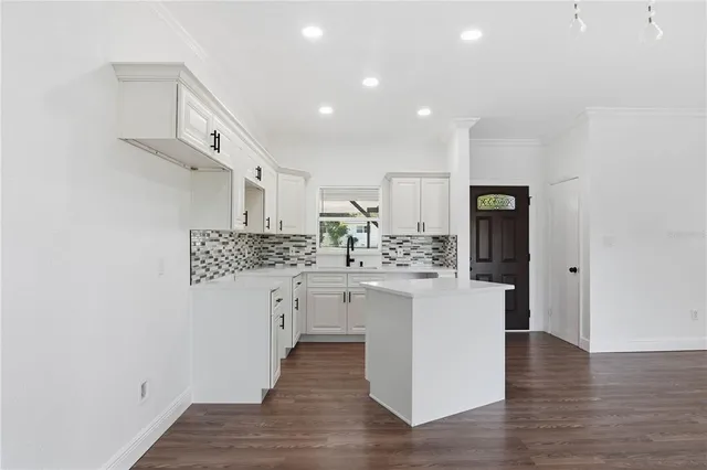 a kitchen with white cabinets and sink