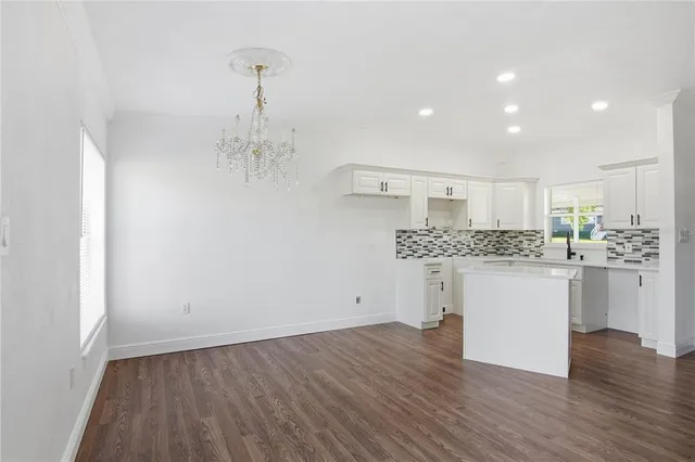 a kitchen with a refrigerator and white cabinets