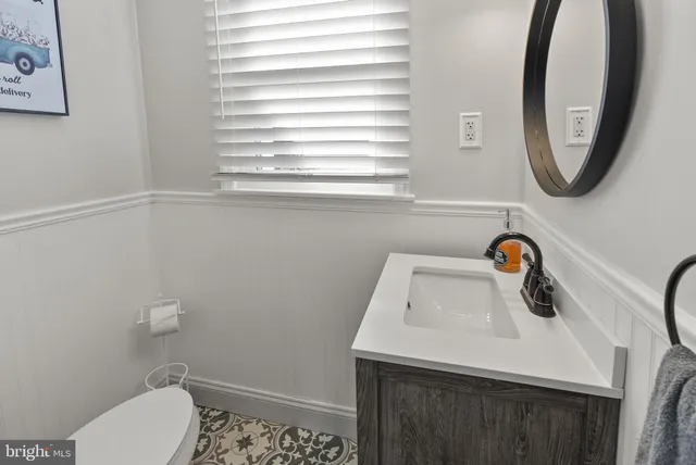a bathroom with a sink a toilet and a mirror