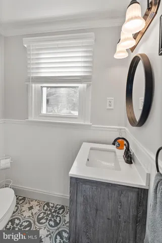 a bathroom with a sink a toilet and a mirror