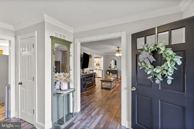 a kitchen with stainless steel appliances granite countertop wooden cabinets a sink dishwasher a stove and a refrigerator with wooden floor