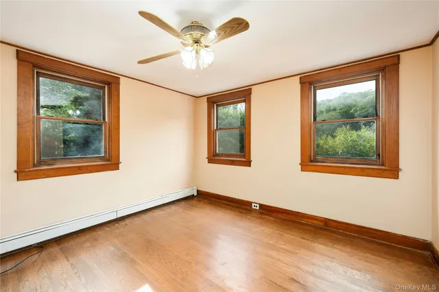a view of an empty room with a window and a ceiling fan
