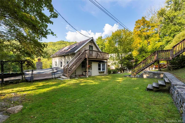a view of a house with a big yard and large trees