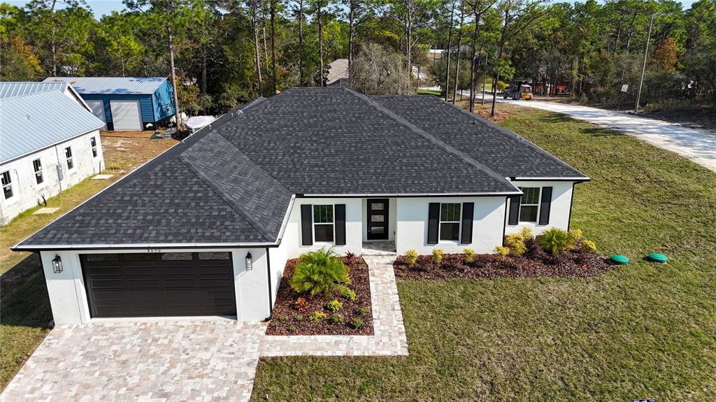 8090 Nordica Road Brooksville, FL 34613 - Photo 1 of 56 a front view of house with yard and trees in the background