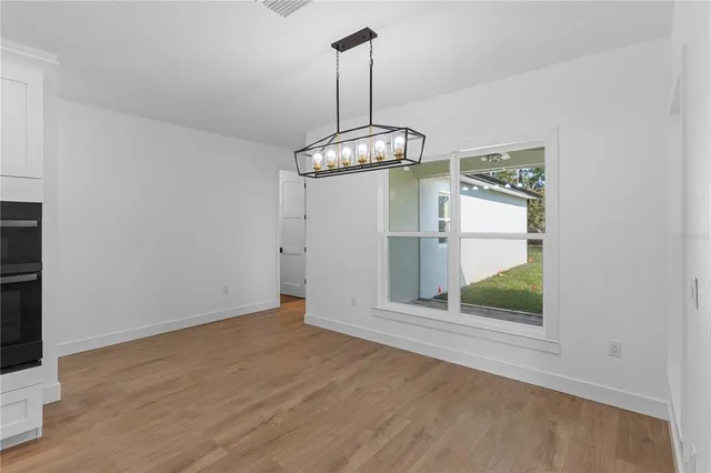 a view of a room with wooden floor and a ceiling fan