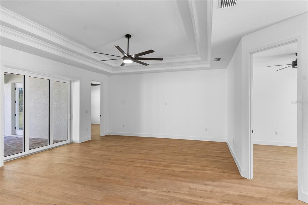 8090 Nordica Road Brooksville, FL 34613 - Photo 12 of 56 a view of a room with wooden floor and a ceiling fan