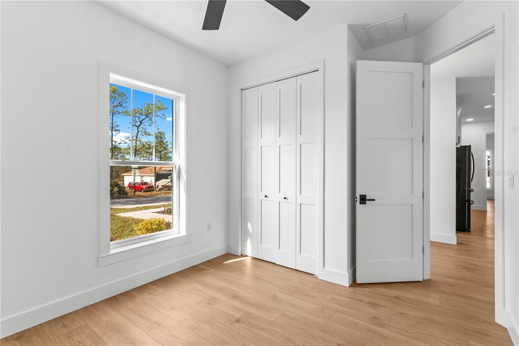 8090 Nordica Road Brooksville, FL 34613 - Photo 16 of 56 a view of an empty room with window and wooden floor