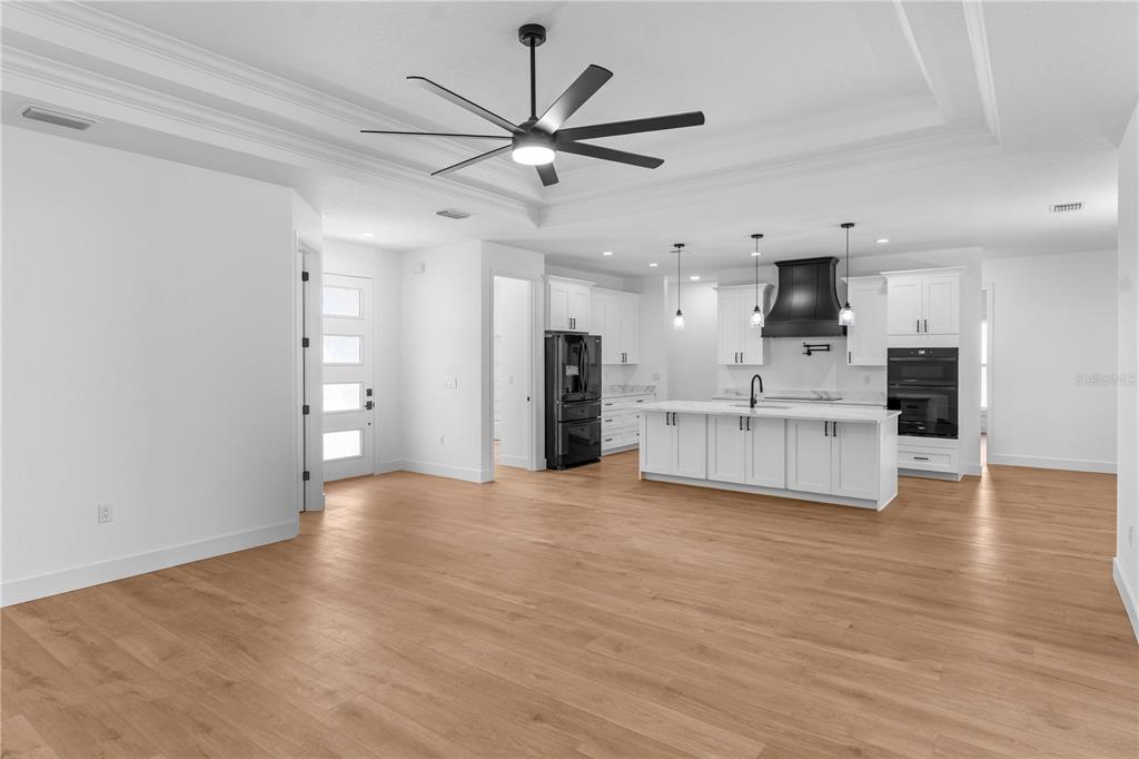8090 Nordica Road Brooksville, FL 34613 - Photo 2 of 56 a view of an empty room with kitchen appliances and a ceiling fan
