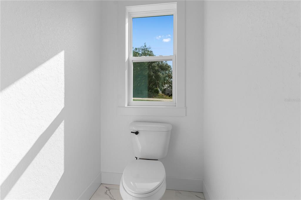 8090 Nordica Road Brooksville, FL 34613 - Photo 22 of 56 a white toilet sitting next to a bathroom sink
