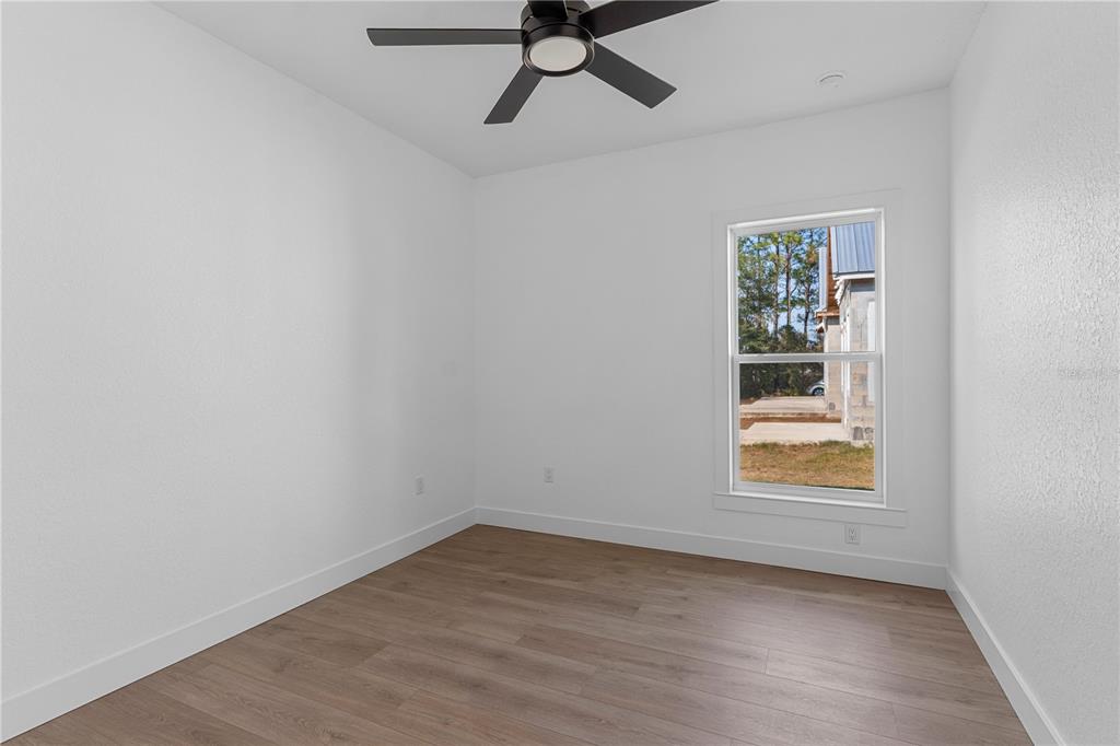 8090 Nordica Road Brooksville, FL 34613 - Photo 28 of 56 an empty room with a window and a ceiling fan