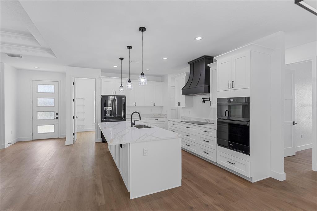 8090 Nordica Road Brooksville, FL 34613 - Photo 3 of 56 a large kitchen with stainless steel appliances kitchen island granite countertop a stove a sink and a refrigerator