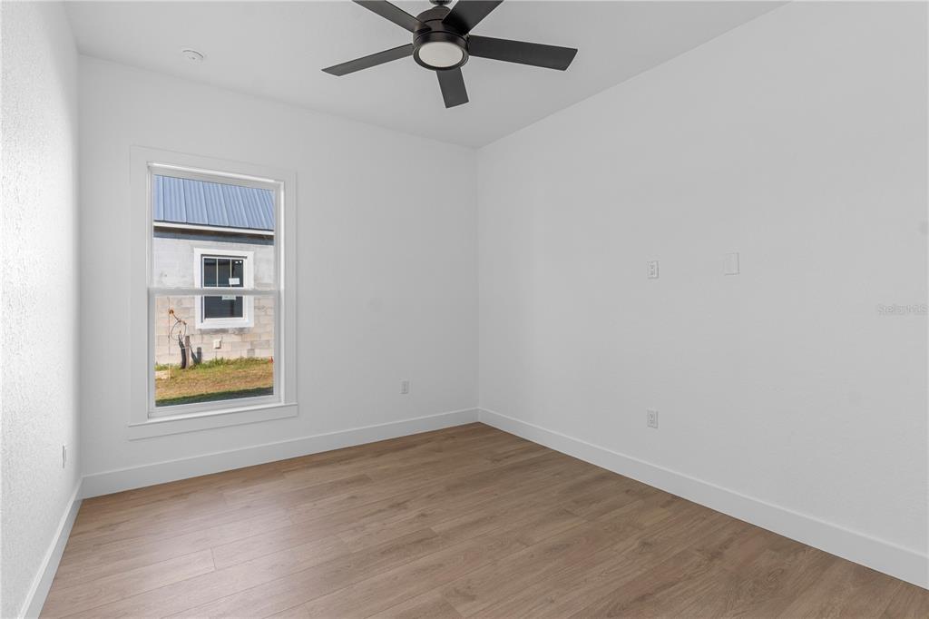 8090 Nordica Road Brooksville, FL 34613 - Photo 31 of 56 an empty room with a window and ceiling fan