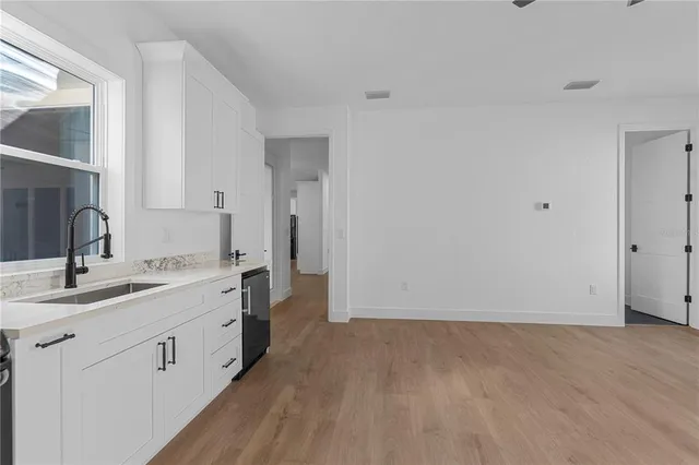 a view of an empty room with window and cabinet