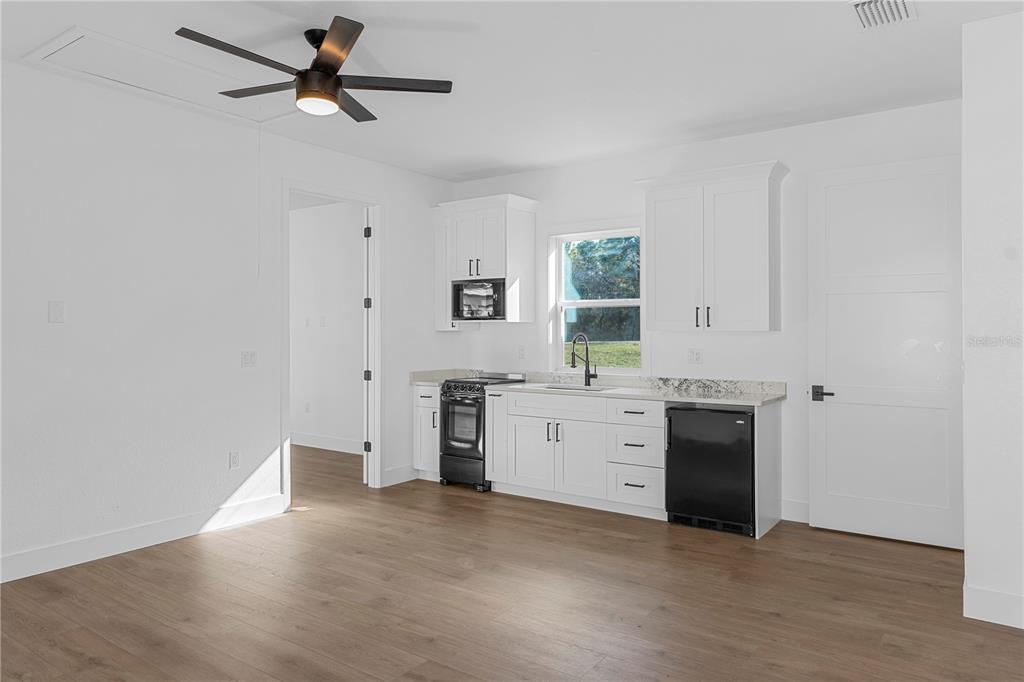8090 Nordica Road Brooksville, FL 34613 - Photo 37 of 56 a view of a kitchen with a stove cabinets and wooden floor