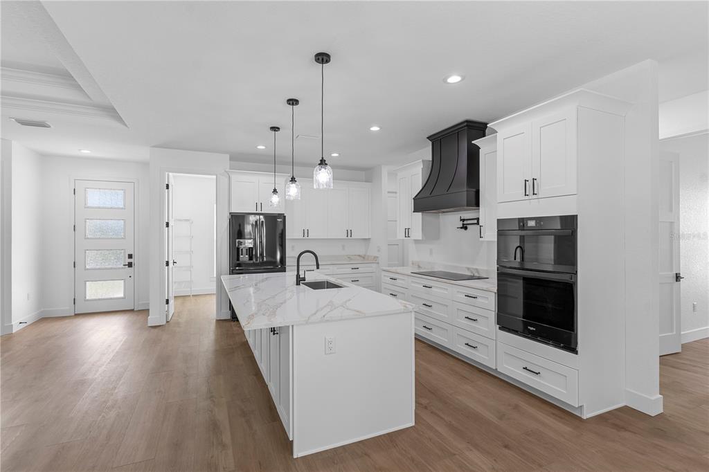 8090 Nordica Road Brooksville, FL 34613 - Photo 4 of 56 a large kitchen with stainless steel appliances kitchen island granite countertop a stove a sink and a refrigerator