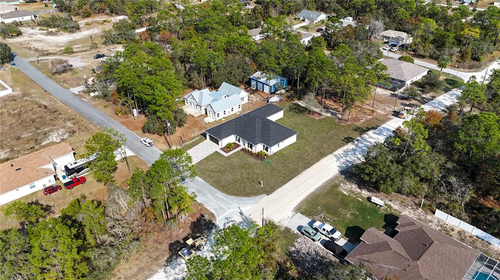 8090 Nordica Road Brooksville, FL 34613 - Photo 54 of 56 an aerial view of a house with a yard and trees all around