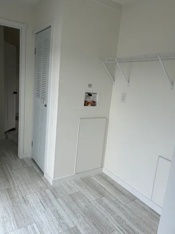 an empty room with wooden floor and window