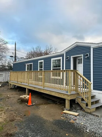 a view of a house with wooden deck and furniture