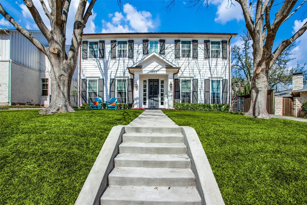 a front view of a house with a yard and garden