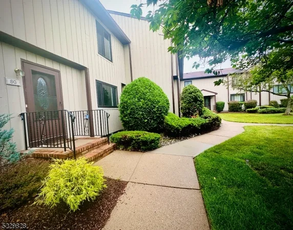 a view of a house with a yard and flower garden