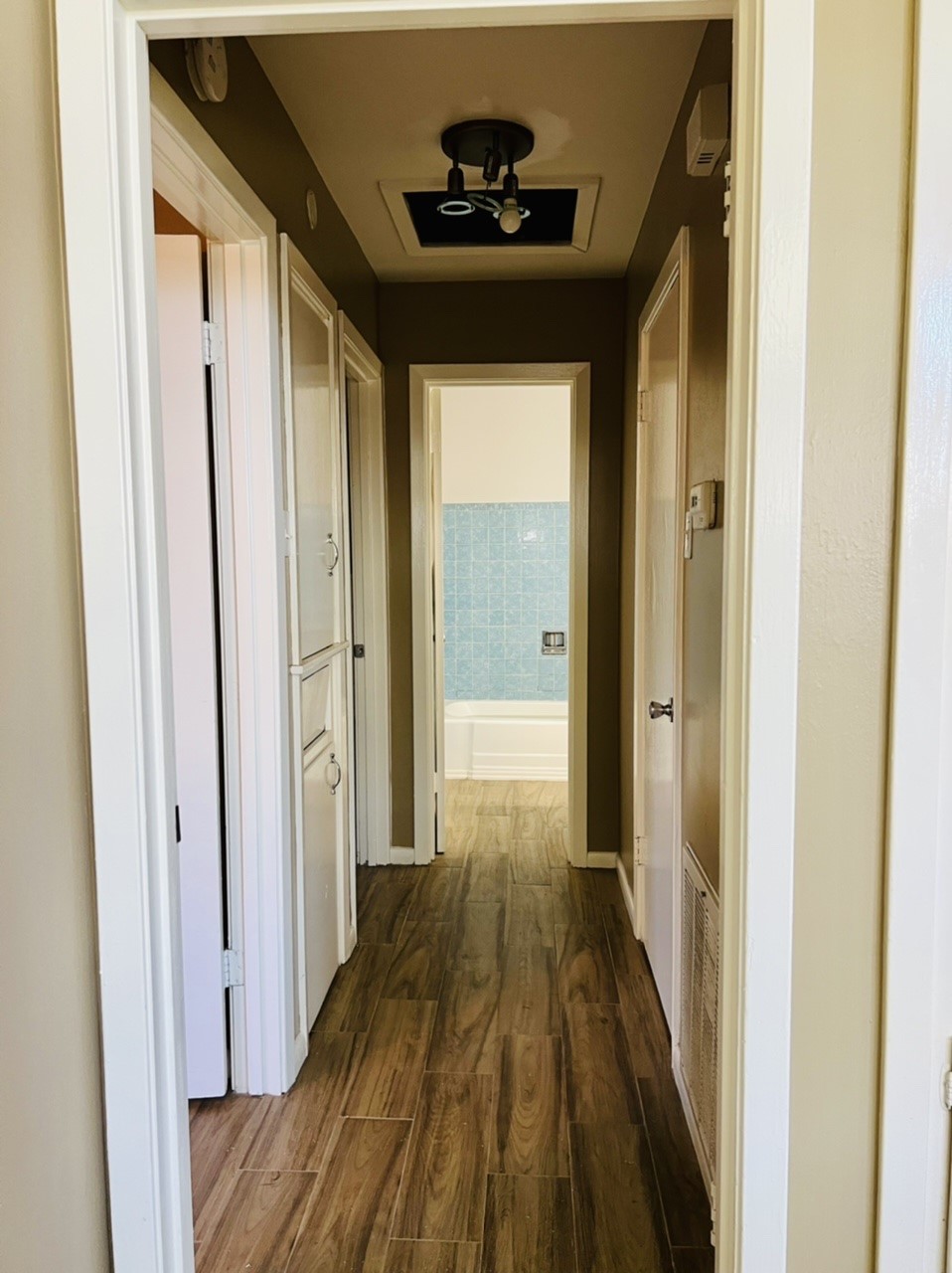 4731 Merwin Street Houston, TX 77027 - Photo 15 of 28 a view of a hallway with wooden floor and a bathroom