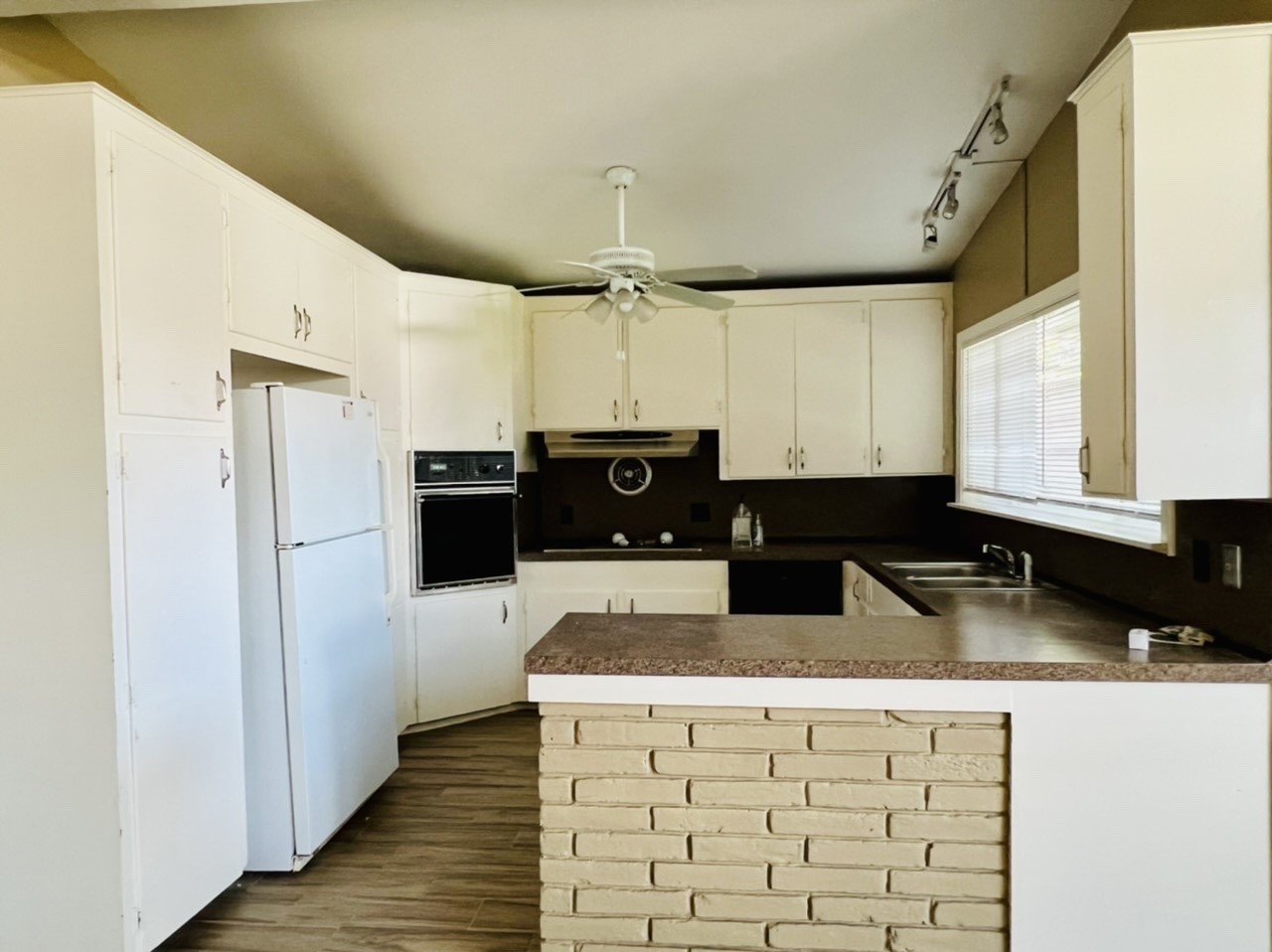 4731 Merwin Street Houston, TX 77027 - Photo 20 of 28 a kitchen with granite countertop a refrigerator a sink and wooden cabinets