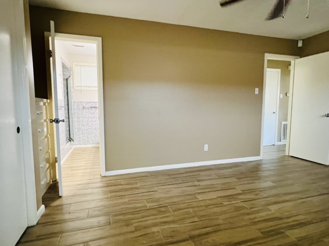 4731 Merwin Street Houston, TX 77027 - Photo 8 of 28 a view of an empty room with wooden floor and a bathroom