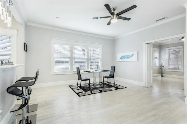a living room with furniture a floor to ceiling window and a ceiling fan