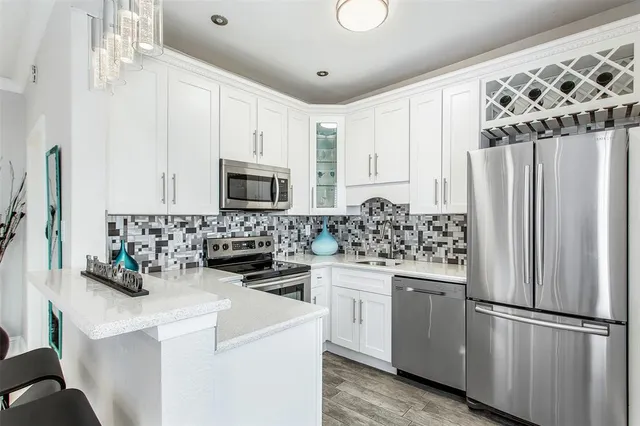 a kitchen with white cabinets and stainless steel appliances