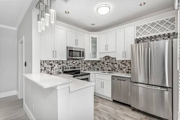 a kitchen with cabinets appliances a sink and a counter top