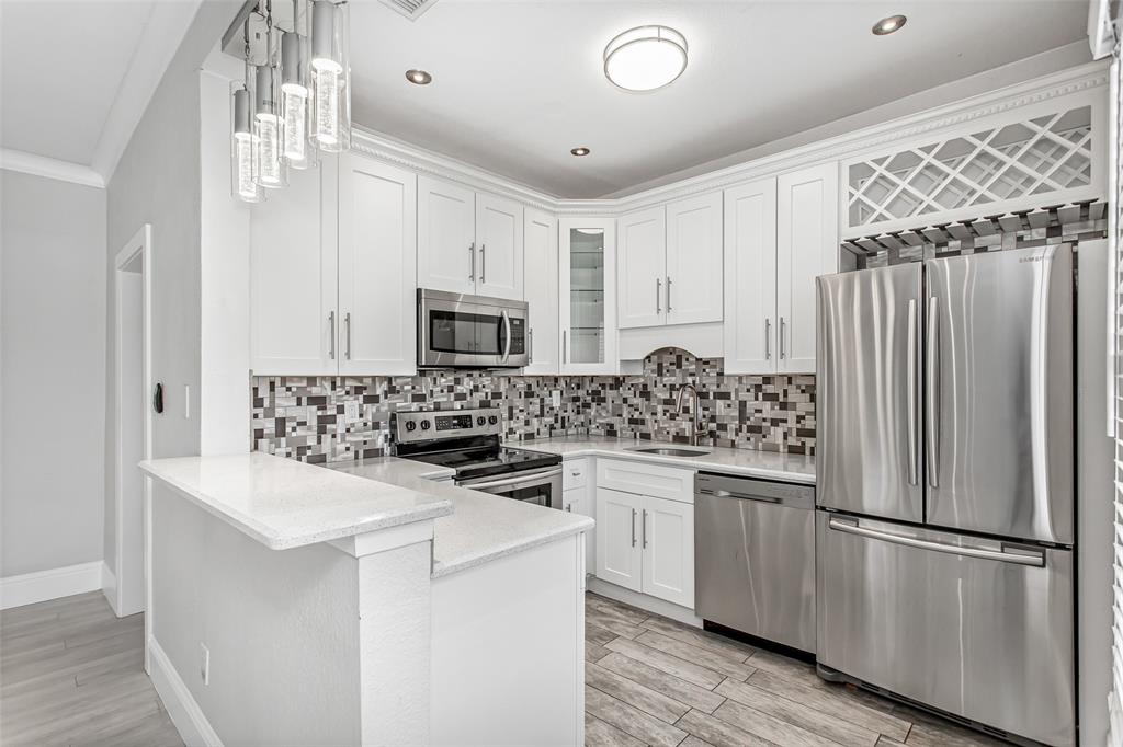 4719 Junius Street, Unit 3 Dallas, TX 75246 - Photo 17 of 38 a kitchen with white cabinets and stainless steel appliances
