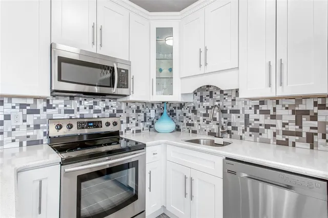 a kitchen with granite countertop a stove sink and microwave