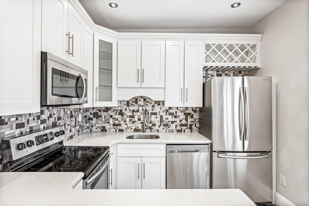4719 Junius Street, Unit 3 Dallas, TX 75246 - Photo 21 of 38 a kitchen with stainless steel appliances a refrigerator sink and cabinets