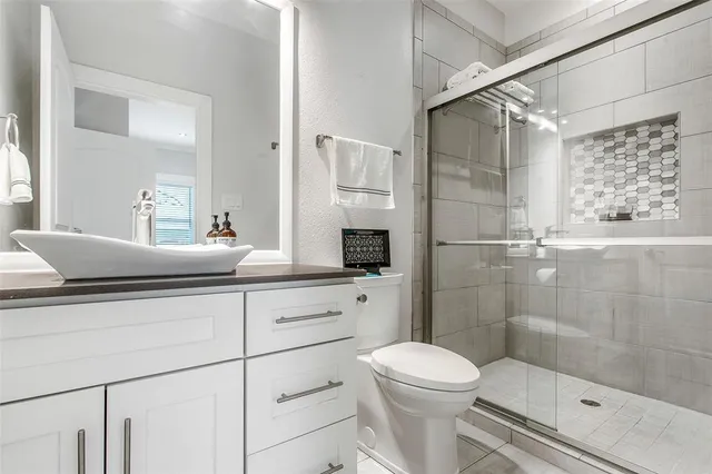 a bathroom with a sink a toilet and shower