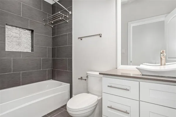 a bathroom with a granite countertop toilet sink and mirror