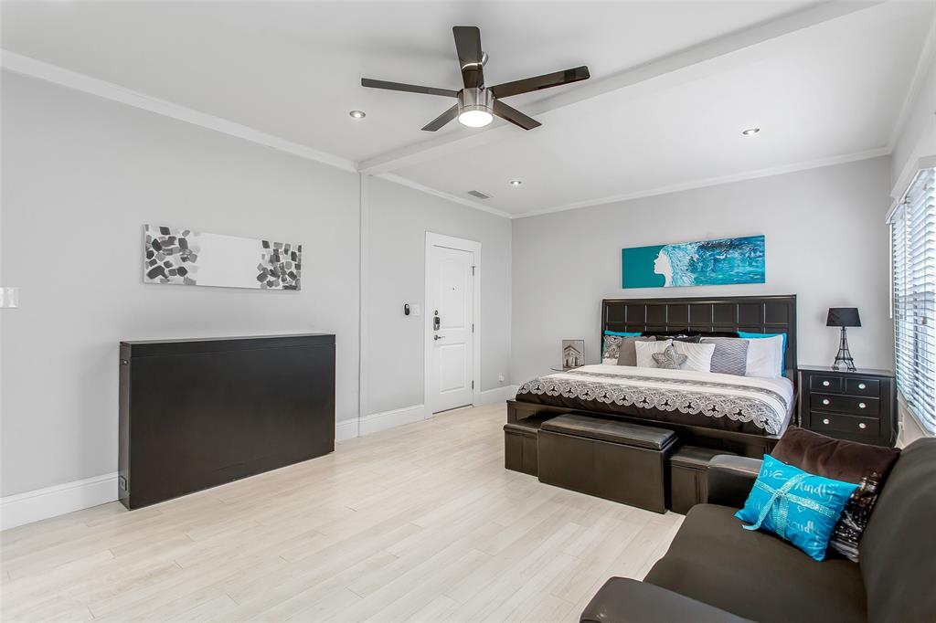 4719 Junius Street, Unit 3 Dallas, TX 75246 - Photo 25 of 36 a spacious bedroom with a bed and a fireplace